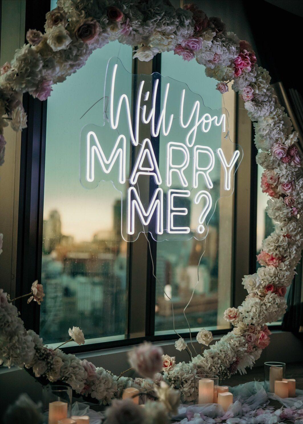 Luxury floral marriage proposal with illuminated Will You Marry Me sign